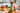 Person preparing vegetables on a wooden cutting board in a kitchen.
