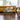 Dog lying on a mustard yellow sofa in a modern living room with a coffee table and books.
