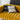 Yellow sofa with patterned cushions against a neutral background