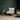 Two armchairs with wooden frames and light gray cushions in a room with a dark green wall.