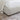 Close-up of a textured bed frame with a white mattress and beige blanket on a patterned rug.
