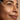 Close-up of a woman's face with a dropper applying a product to her skin.