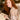Woman with red hair holding a book in a cozy indoor setting