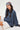 Woman wearing a blue sweatshirt and patterned headscarf on a white background