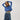 Person wearing a blue knitted sweater and blue pants on a white background