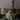 Two ghost-shaped candles on a table with a candlestick in the background.