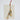 Decorative brass bell with tassels on a textured beige surface.