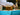 Person in beekeeping suit inspecting honeycomb with a blurred background