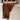 Brown towel with tassels draped over a white bathtub in a bathroom setting.