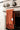 Burnt Orange hand towel hanging on a silver oven handle with a white label.