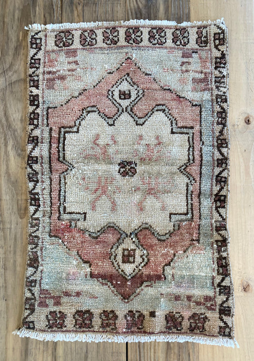 Authentic Turkish rug in beige, rose pink and dark brown with hints of pale blue.
