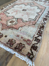 One-of-a-kind hand knotted area rug on a reclaimed wood table. 