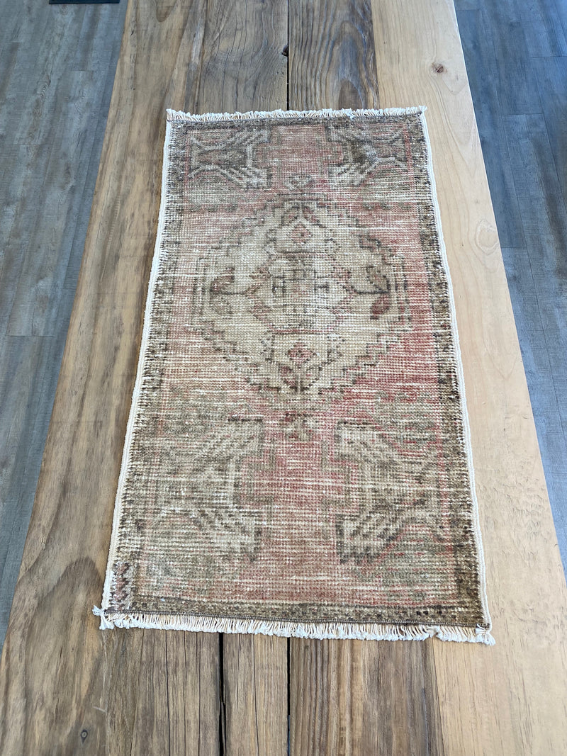 Turksih area rug in a faded pale pink with beige. 
