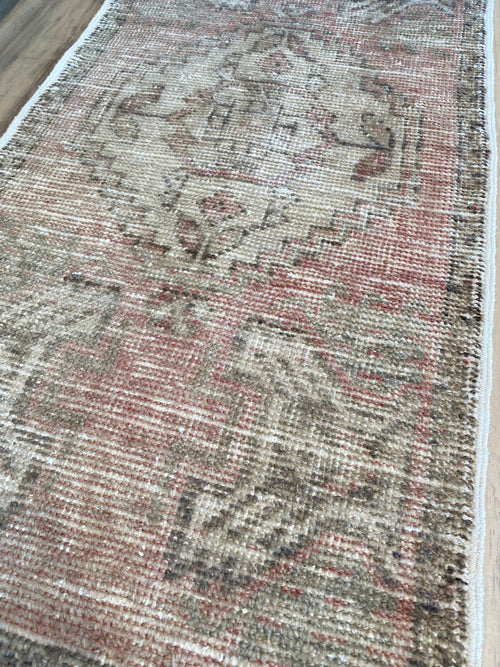 Pale pink, beige and light brown are the main colours in this Turkish are rug. 