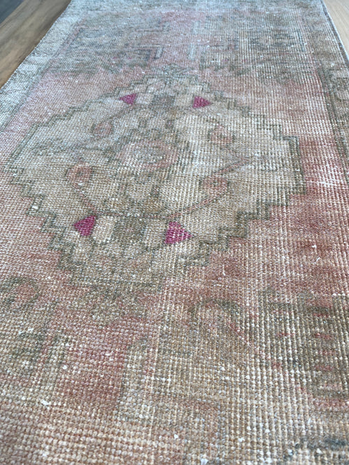 Pale pink rug with fuchsia accents. 