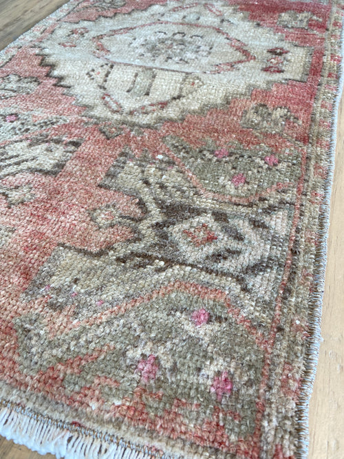 Up close view of the Turkish rug in shades of pink, beige and brown. 