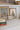 Vintage inspired artwork in ornate frames leaning against a backsplash on a kitchen counter. 
