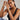Woman wearing multiple bracelets on her wrist against a neutral background