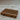 Wooden soap dish on a textured surface with a blurred background