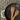 Black frying pan with wooden spatulas on a textured surface