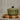 Green ceramic pot with a black handle on a wooden cutting board.