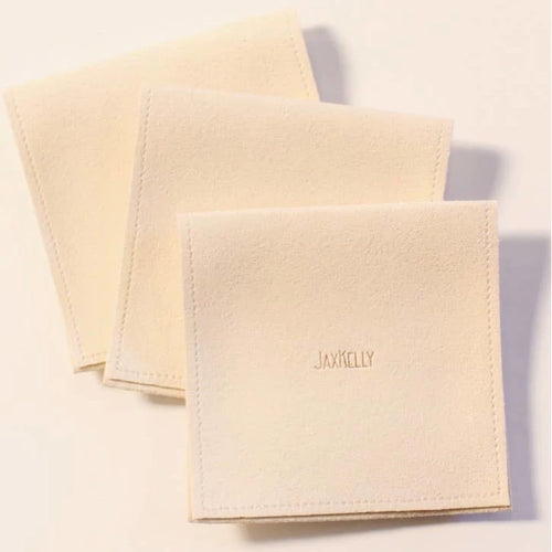 JaxKelly suede-feel jewelry pouch in a cream color.