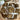 Three brown textured knit washcloths tied with white ribbon bows, arranged inside a wooden bowl on a wooden table.