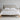 Beige upholstered bed with wooden frame in a minimalistic bedroom setting.