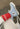 Light blue Converse sneaker worn with a red sock on a concrete floor.