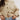 Beige knitted cardigan worn by a person on a plain background.