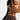 Close-up of a person with braided hair wearing a silver hoop earring on a white background.