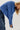 Person wearing a blue knitted sweater with a plain background