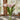 Pink tulips in a clear vase on a table with a blurred indoor background