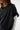 Person wearing a black oversized shirt with a white background