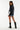 Woman wearing a black oversized shirt, denim shorts, and black boots on a white background