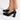 Black high-heeled shoes worn with a white background
