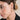 Close-up of a woman wearing gold hoop earrings with a neutral background