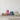 Colorful fabric bags stacked on a wooden surface with a white background
