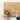 Person using a brush to apply wax from a small container on a wooden cutting board.