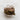 Folded knitted fabric in beige, brown, and green on a textured white surface