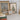 Framed winter-themed prints on a shelf with books and decorative items.