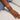 Hand wearing multiple bracelets on a light background