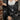 Person wearing a black and white patterned outfit against a brick wall.