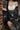 Person wearing a black and white patterned outfit against a brick wall.