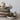 Stack of ceramic bowls and mugs with natural elements on a light surface