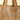 A close-up of a woven tote bag featuring a pattern of stylized tigers and wavy stripes in brown, beige, and black, with matching patterned shoulder straps.