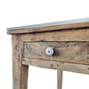 A rustic wood kitchen island with a porcelain drawer pull. 