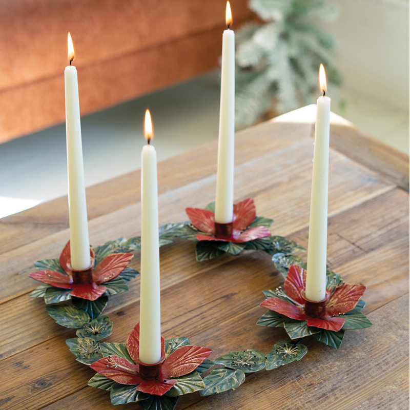 Poinsettia Table Wreath as a centerpiece on a rustic coffee table with 4 taper candles burning. 