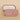 Pink jewelry case with gold earrings on a beige background