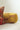 A round cylindrical lumbar pillow in mustard yellow velvet with a printed pattern of walking spotted big cats, shown next to a matching patterned decorative pillow on a white surface against a light gray background.